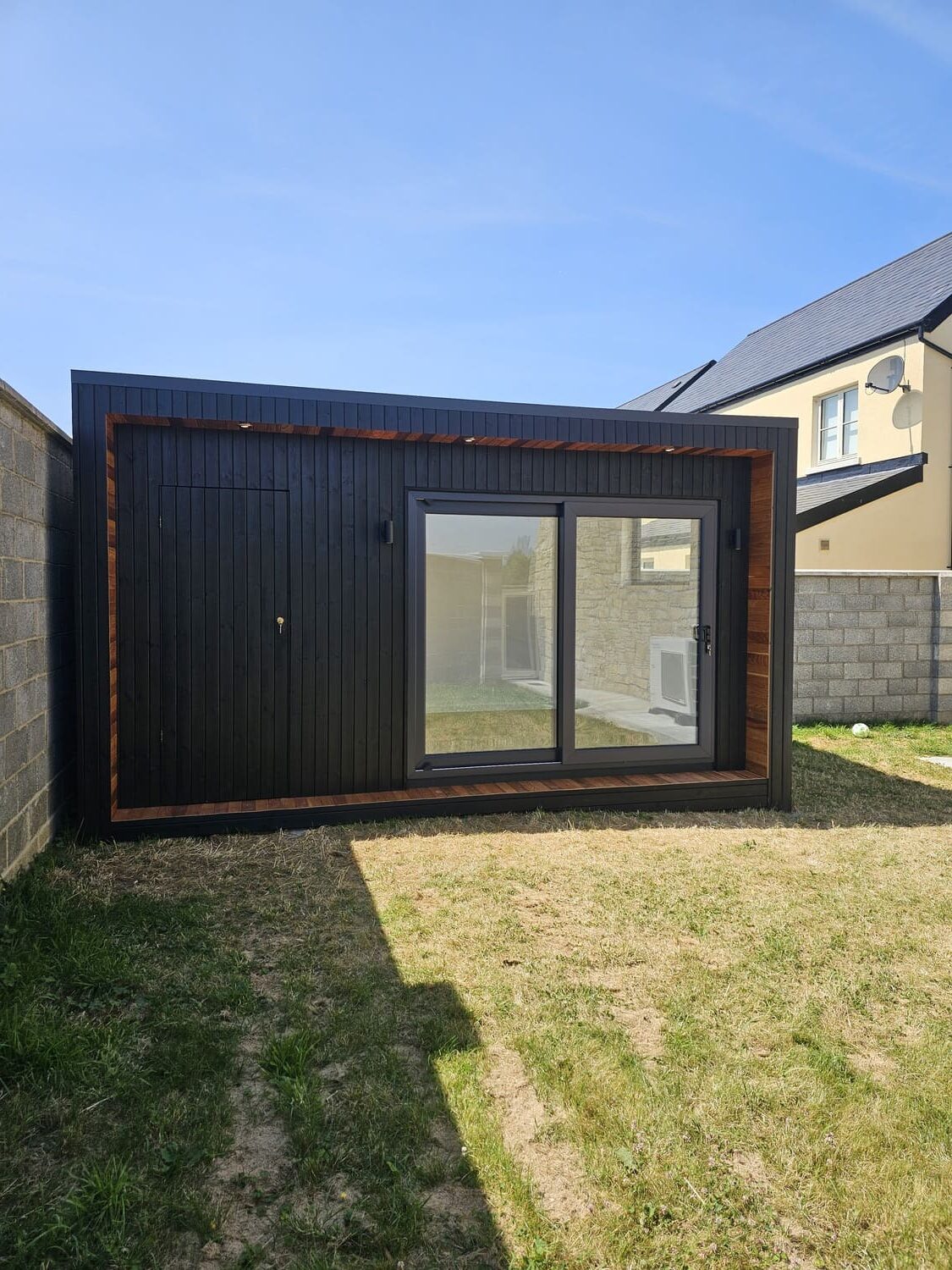 Black garden room in Ardclough Co. Kildare with cedar corner accent and anthracite sliding doors